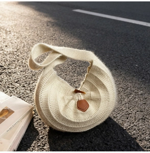 Détail du sac bandoulière en tricot avec boucle en corne et plis ondulés élégants