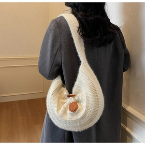 Détail du sac tricoté blanc avec fermoir en corne brune et texture en mohair doux