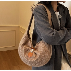 Vue détaillée du sac à bandoulière en tricot marron avec fermeture à bouton en bois