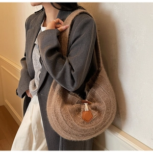 Détail du sac en maille avec bouton en corne de bois et texture douce tissée