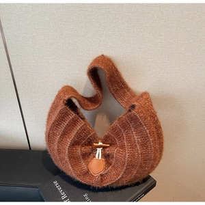 Gros plan du sac à bandoulière en tricot marron avec motif rayé et boucle en corne