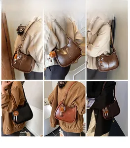 Viste dettagliate della borsa a secchiello vintage con charm in peluche, marrone e nera