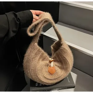 Détail d'un sac à main en maille marron avec fermoir bascule et garniture en cuir