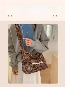 Detail of plush leopard print crossbody bag with white zip pocket and warm lamb wool texture