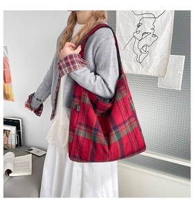 Detail of red and blue checkered tote bag showing Malivi brand tag and woven texture