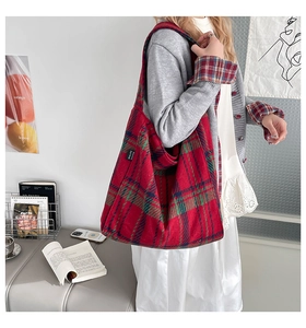 Macro detail of red plaid tote bag featuring thick wool fabric and brand label