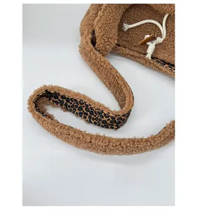 Detail of plush tote bag showing leopard print strap, horn buckle and white drawstring