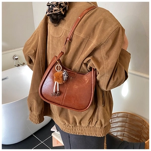 Borsa hobo marrone vintage con ciondolo leopardato indossata da una modella