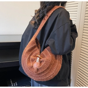 Gros plan détaillé du sac hobo en tricot marron avec fermoir en bois et détails en cuir