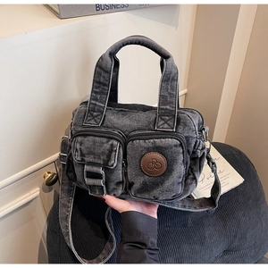 Detail of washed grey denim tote bag with functional pockets and retro texture