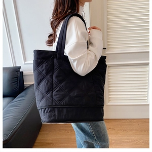 Close-up of quilted tote bag with diamond pattern on a female model shoulder