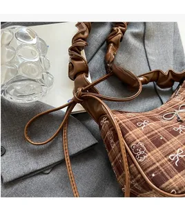 Detail of vintage brown checkered canvas bag featuring bear prints and silver bow hardware