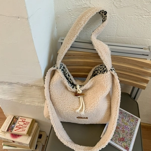 Close-up of beige plush tote bag with leopard lining and wooden button detail