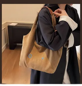 Detail of dark brown canvas tote bag featuring premium blue GTYLF 3D embroidery and leather straps