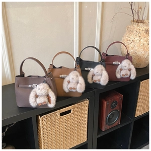 Retro bucket bags in four colors featuring a metal lock and plush rabbit pendant decor