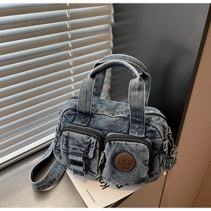 Detailed texture of washed denim small square bag with brown leather logo patch