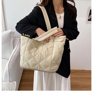 Detail of cream quilted tote bag showing large capacity and soft padded diamond pattern
