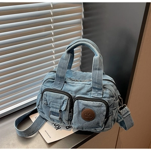 Detail of blue denim square bag with exterior pockets and adjustable strap for women