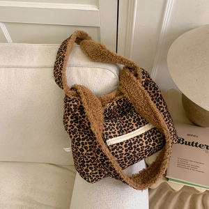 Detail of plush leopard print crossbody bag featuring brown sherpa trim and zipper pocket