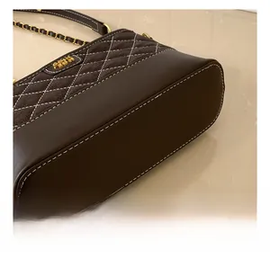 Detail of dark brown quilted bag showing white contrast stitching and leather textures