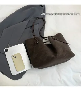 Brown tote bag size comparison with a phone and tablet on white fabric background