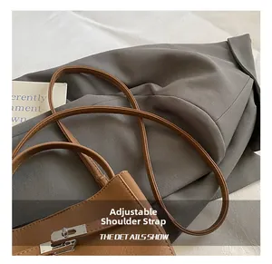 Close-up of brown lychee grain leather bucket bag with silver metal lock and strap