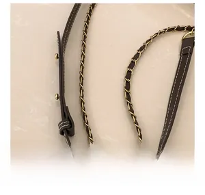 Detail of adjustable dark brown lychee leather shoulder strap with light gold metal chain