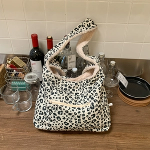 Detail of leopard print tote bag with plush lining and front zipper pocket detail