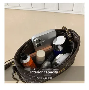 Top view of dark brown quilted bag interior showing capacity for cosmetics and phone