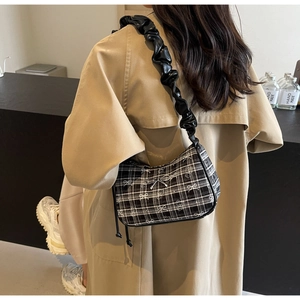 Detail of checkered underarm bag with white bows and silver bow clasp decoration