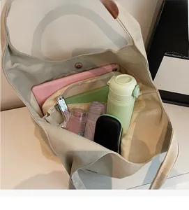 Detail of spacious beige canvas tote interior with metal magnetic closure and large capacity