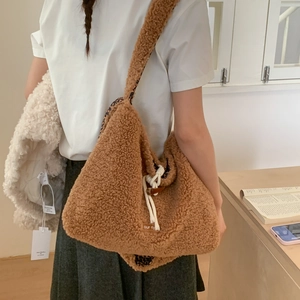 Detail of plush brown shoulder bag featuring leopard print lining and drawstring closure