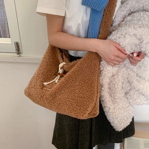 Detail of teddy fleece shoulder bag showing brown textured fabric and toggle closure