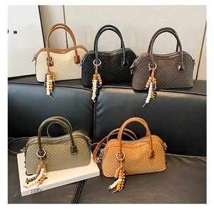 Detailed view of mini Boston bags in five colors with woven texture and beaded charms