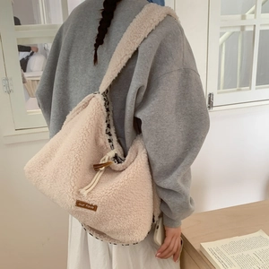 Detail of plush off-white tote bag with toggle horn button and animal print lining