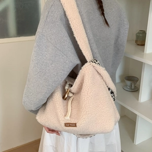 Detail view of cream fleece shoulder bag featuring leopard print lining and drawstring closure