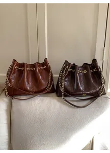 Detailansicht der gesteppten Hobo-Tasche aus Leder mit goldener Kette und Rautenmuster
