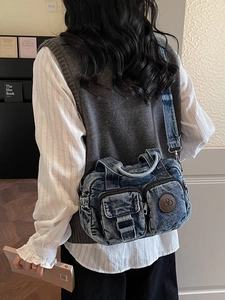 Vintage washed denim crossbody bag with multi-pocket design shown on model shoulder