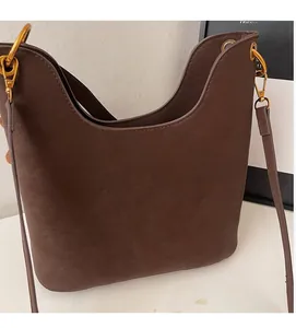 Detailed view of dark brown pebbled leather texture and gold metal hooks on a tote bag