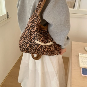 Detail of plush leopard print tote bag with soft faux fur lining and front zipper pocket
