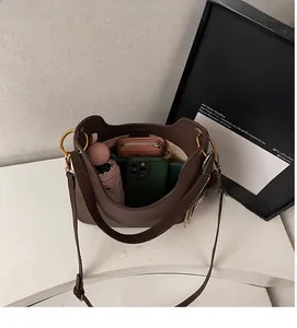 Interior view of brown leather bucket bag showing capacity with phone and umbrella