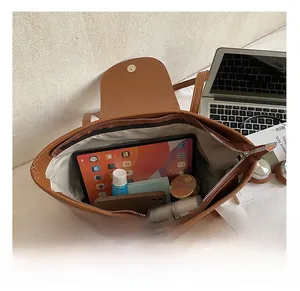 Detailed interior of the vintage brown tote bag showing large capacity for laptop and daily items
