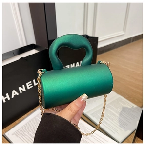 Détail du mini sac cylindre en acrylique vert avec texture mate et chaîne dorée