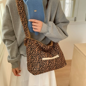 Detail of plush leopard print crossbody bag featuring fuzzy texture and zipper pocket