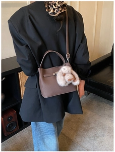 Detailed view of brown textured PU leather bucket bag with cute plush rabbit charm