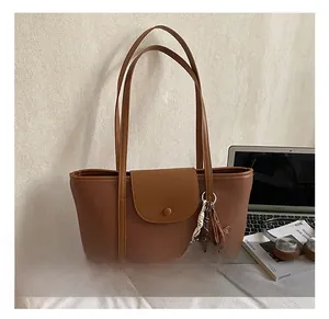 Detailed view of brown PU leather tote bag with flap closure and decorative bear charm