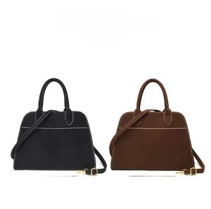 Detail of vintage large capacity handbags in black and brown with white contrast stitching