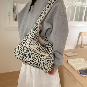 Detail of hobo bag featuring leopard print fabric and soft cream faux fur lining
