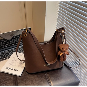 Detailansicht braune Shopper-Tasche mit Teddybär-Anhänger und Metallring-Akzent