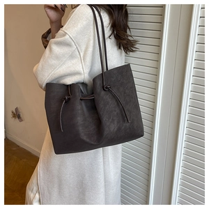 Detail of dark brown leather tote bag showing knot strap design and large capacity